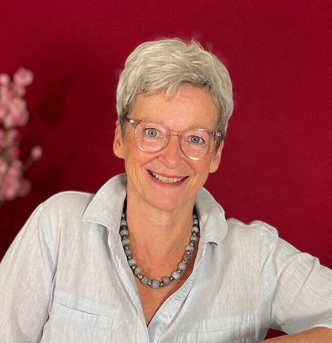 Marie-Luise auf eine Nähmaschine gestützt